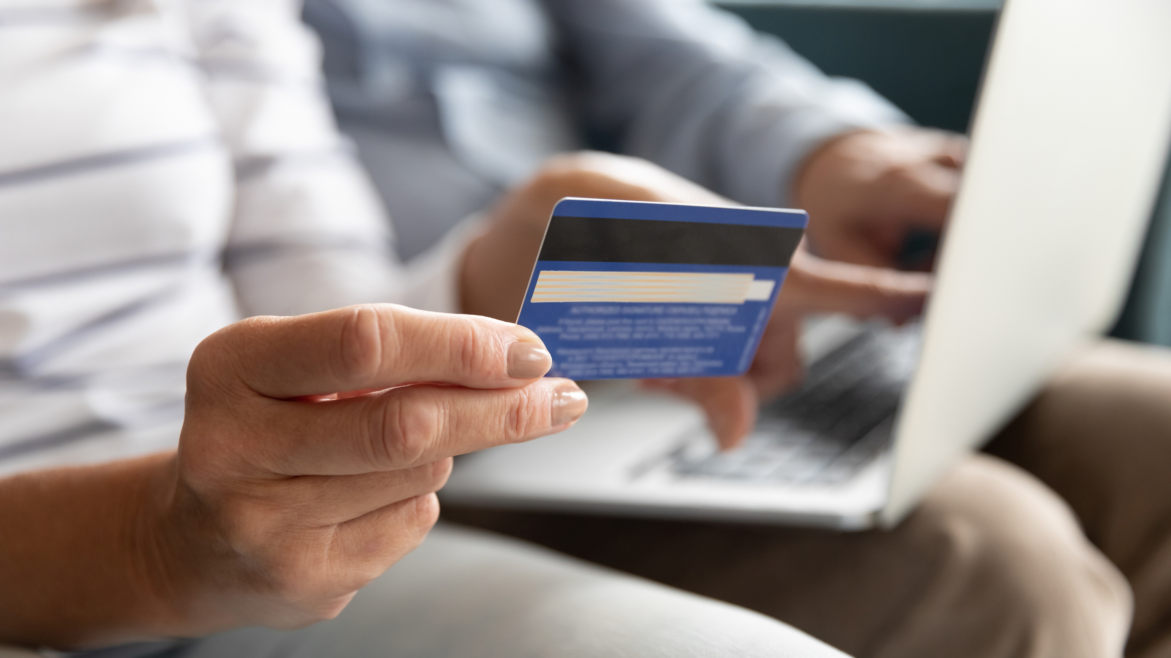 Woman holding a credit card making an online payment
