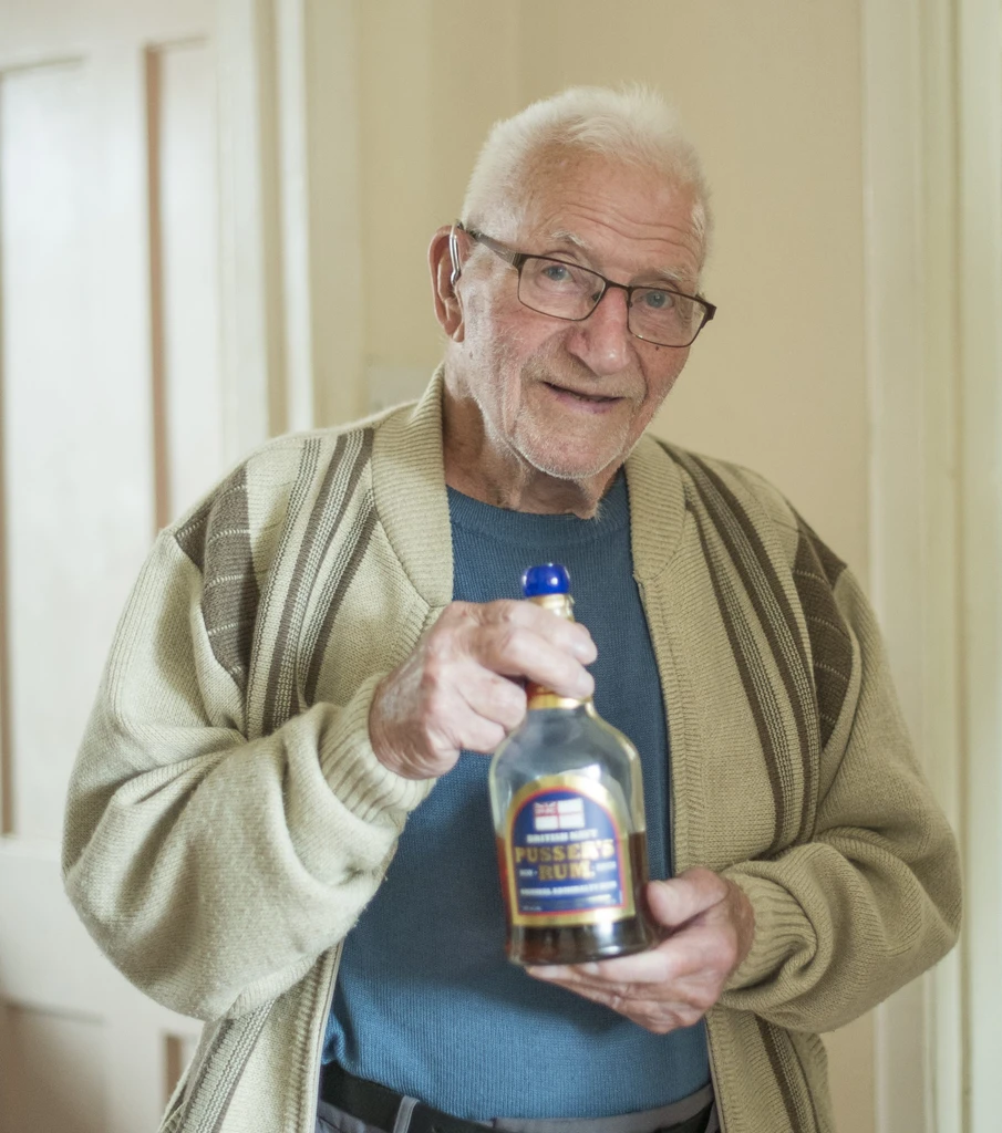 Dennis holding his favourite bottle of rum