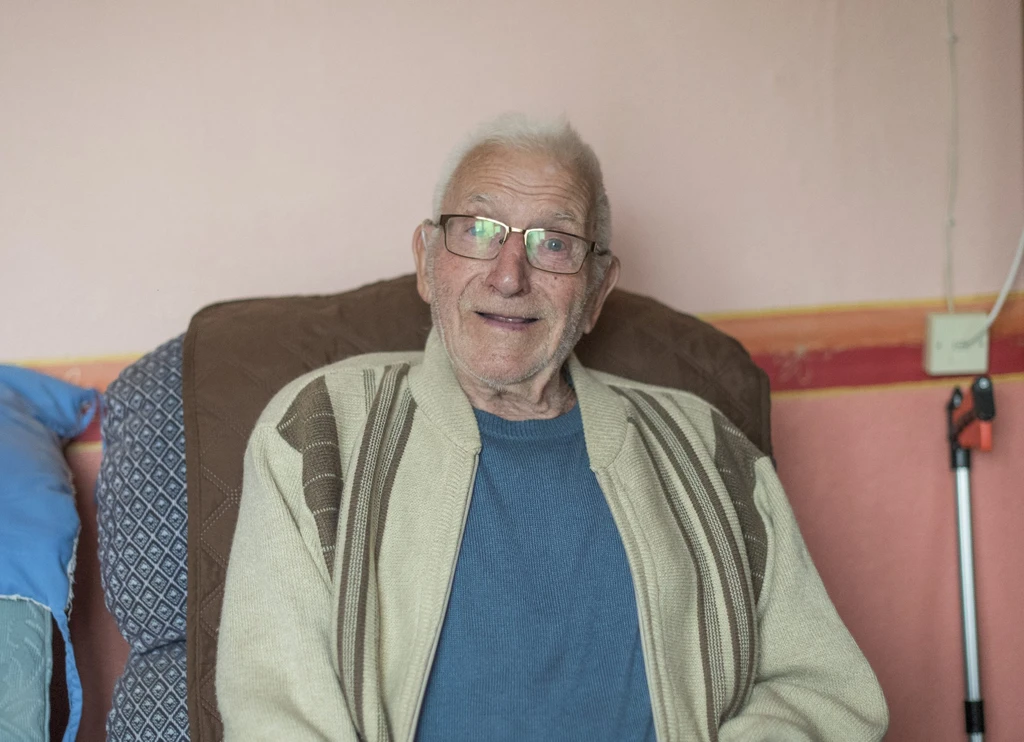 Dennis sitting in his armchair, smiling