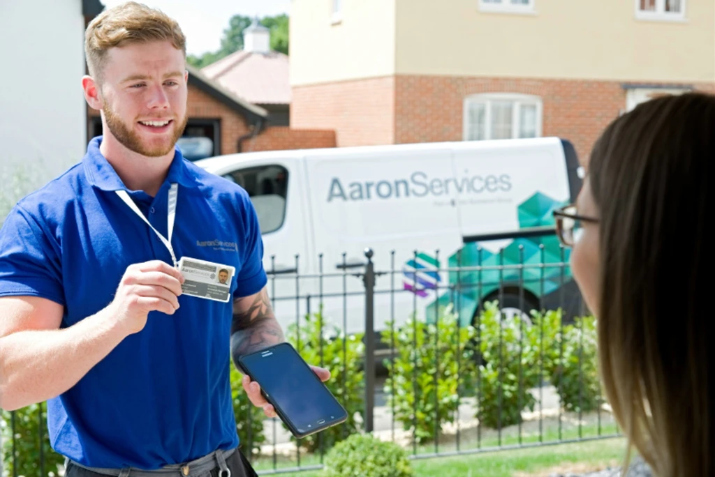 A man working for Aaron Services showing his ID card to a customer