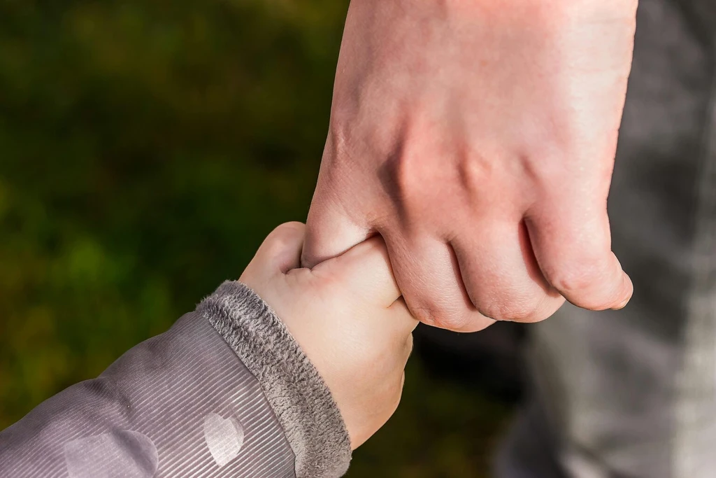 A person holding a child's hand