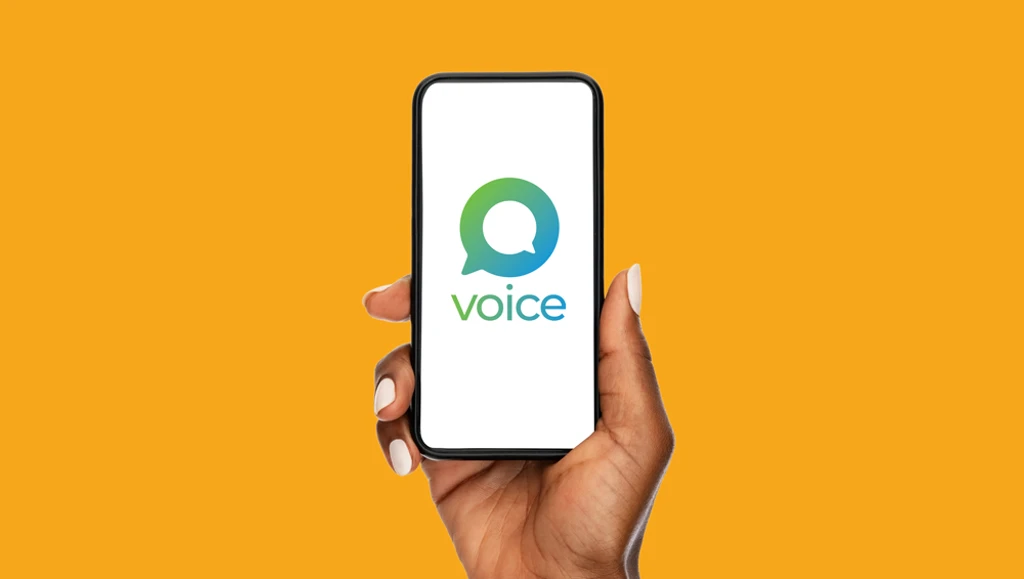 Hand holding a smartphone displaying the Voice logo on screen